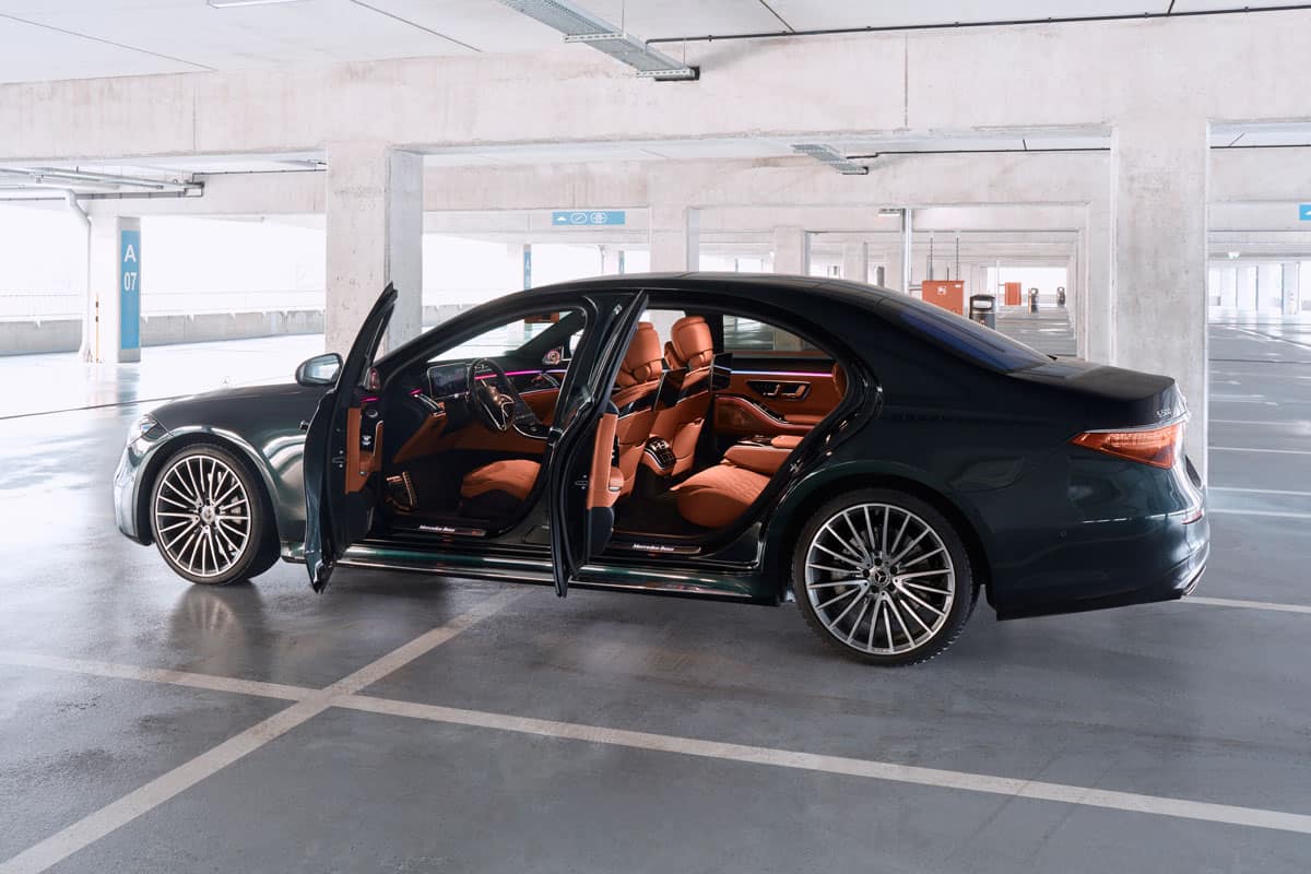 Luxurious Mercedes S Class with open doors, standing on an underground parking lot