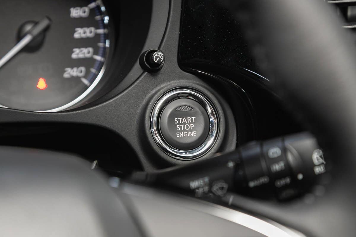 Mitsubishi Outlander, Car dashboard: black engine start stop button, car interior details. Soft focus