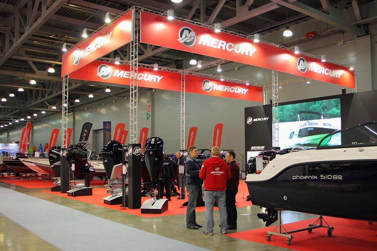 People visitors and managers staff at the Mercury exhibition stand with boat and outboards