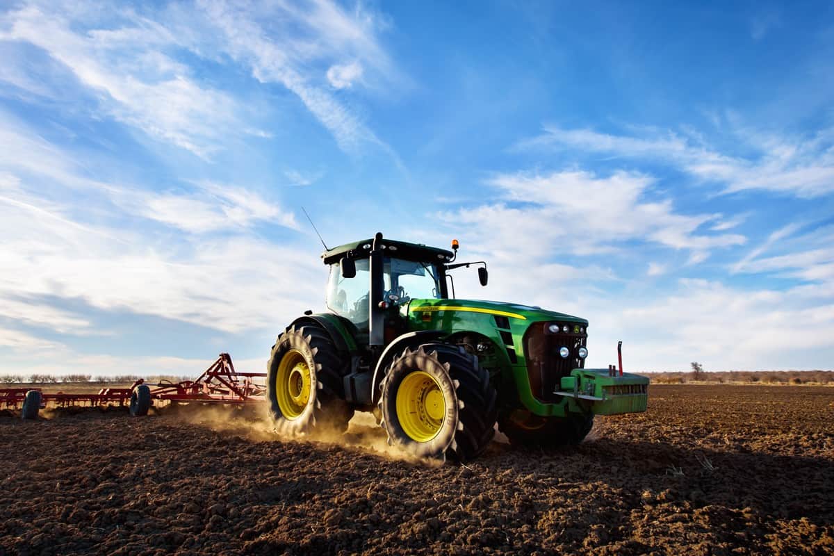 Ploughing a field with John Deere 6930 tractor. John Deere was manufactured in 1995-1999 and it has JD 7.6L or 8.1L 6-cyl diesel engine.