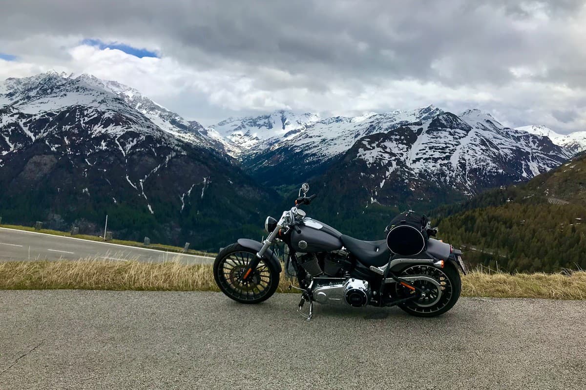 Using powerful Harley Davison cruiser on an uphill terrain showing the snow capped mountains on the back