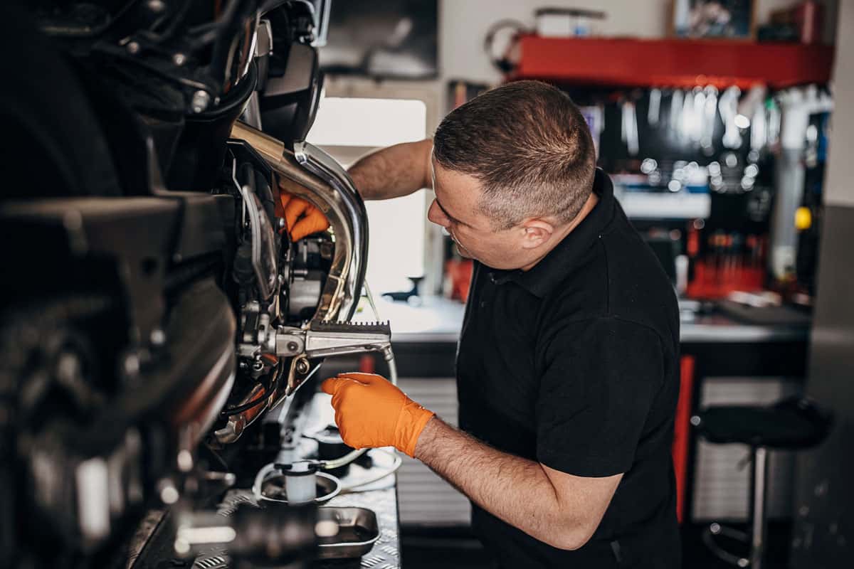 man mechanic oil change motorcycle repair fix maintenance