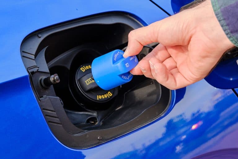 mans hand opening a tank for Ad Blue fluid of a blue car, Diesel Exhaust Fluid Will Not Reset - Why And What To Do?