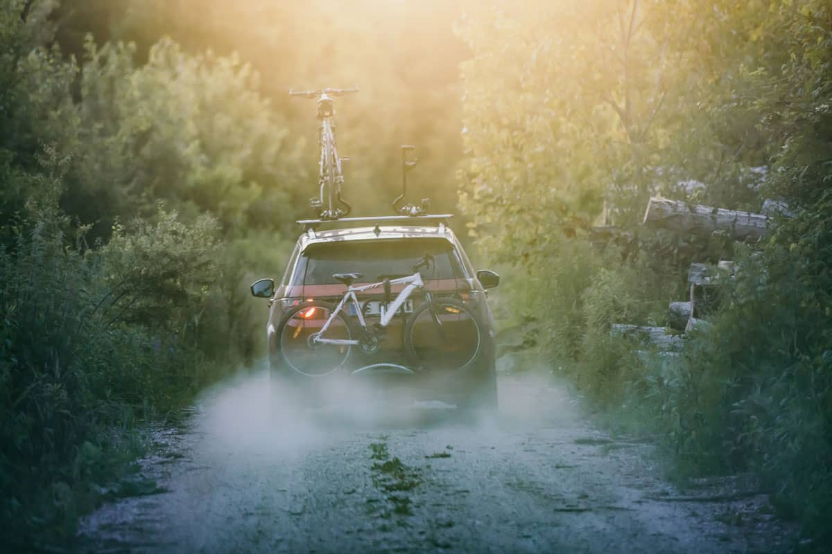 photo of a off-road-car-carrying-mountain-bikes-on-a-rack-in-the-middle-of-the-forest