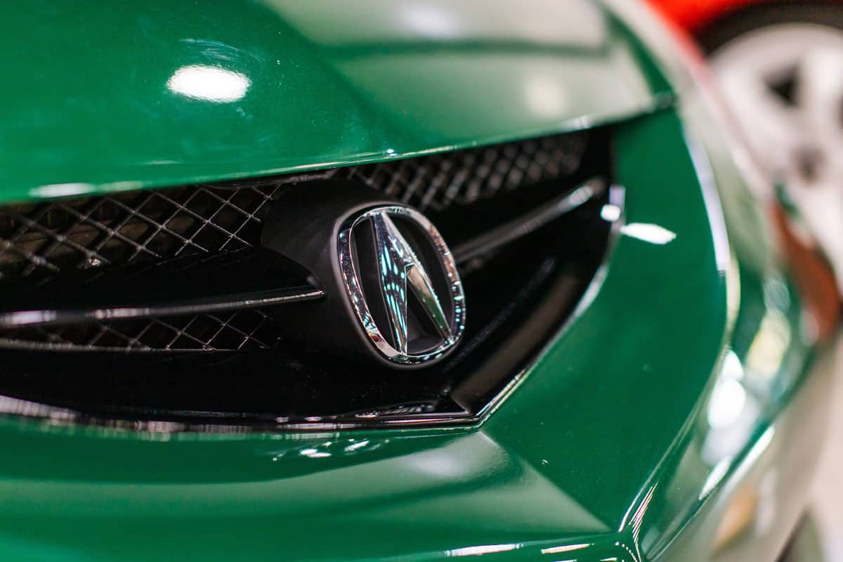 close up glossy dark green acura car front grill