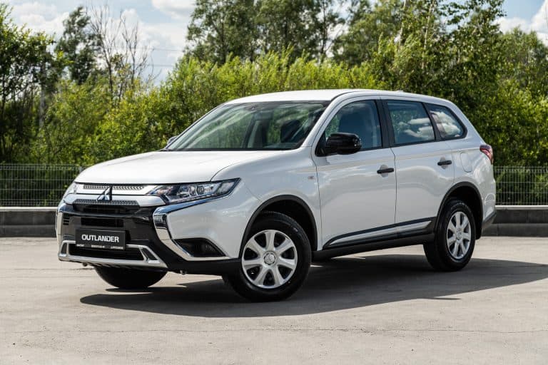 white Mitsubishi Outlander, popular jeep car parked outdoors on a warm summer day, front view - Mitsubishi Outlander Won't Turn Off—Why And What To Do