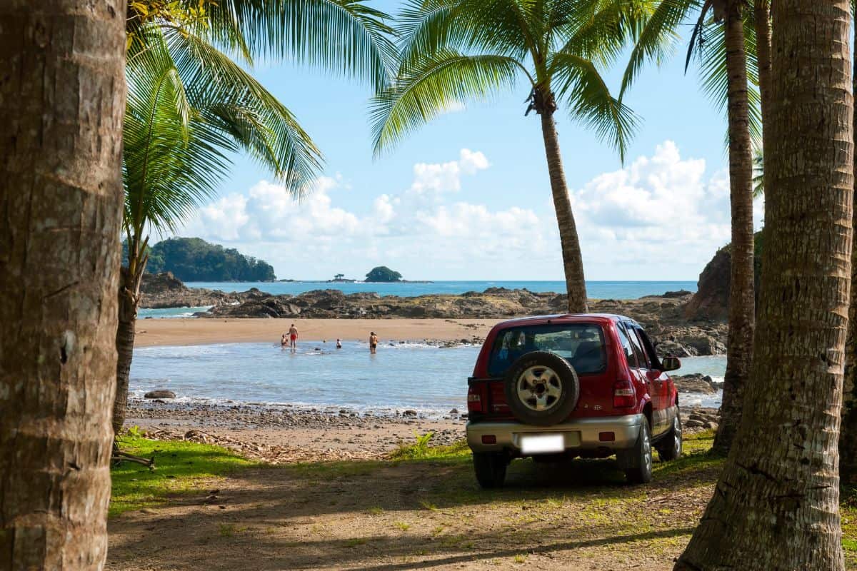  A Kia Sportage is parked among palm trees as a family enjoys the beach near the Pacific coast town of Dominical.