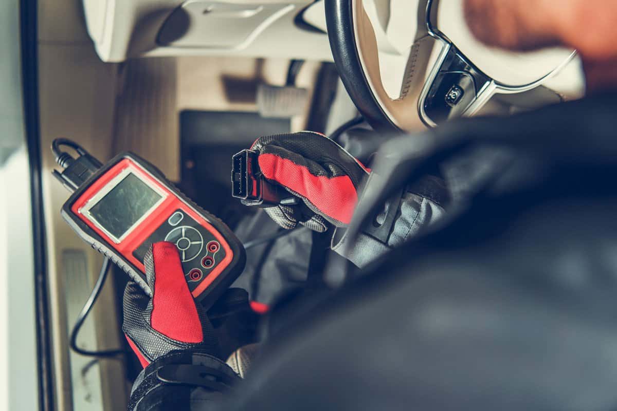 Auto Service Diagnostic Tool in Hands of Vehicle Maintenance Worker. Car Computer Error Reading Using Mobile Device.