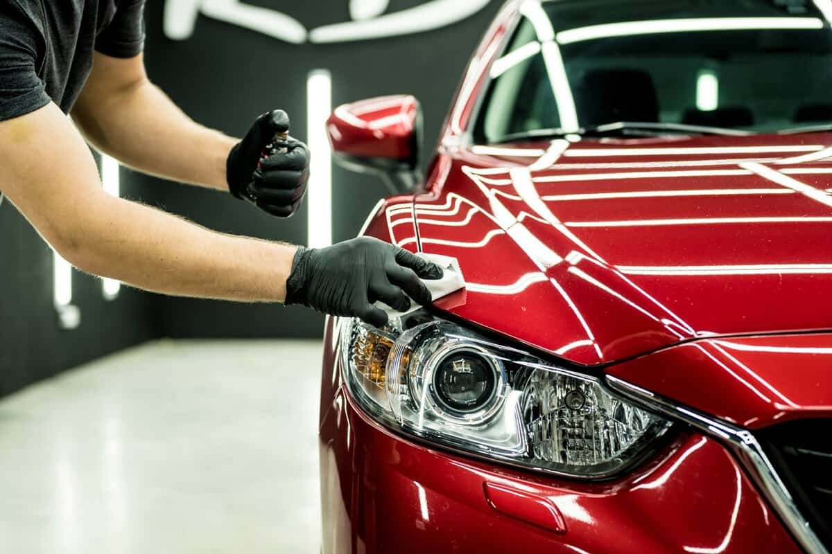 Car service worker applying nano coating on a car detail. 