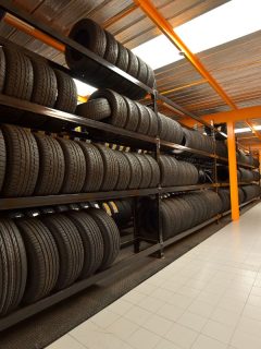 Large modern warehouse with forklifts and stack of car tires. - Do Bigger Tires Need More PSI?