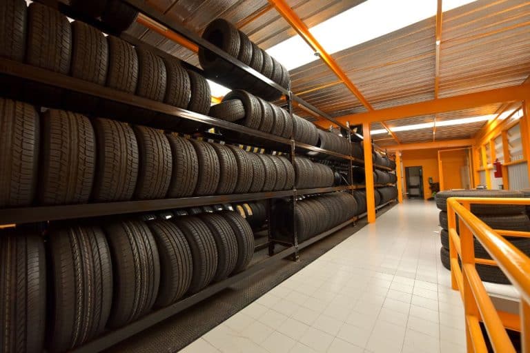Large modern warehouse with forklifts and stack of car tires. - Do Bigger Tires Need More PSI?