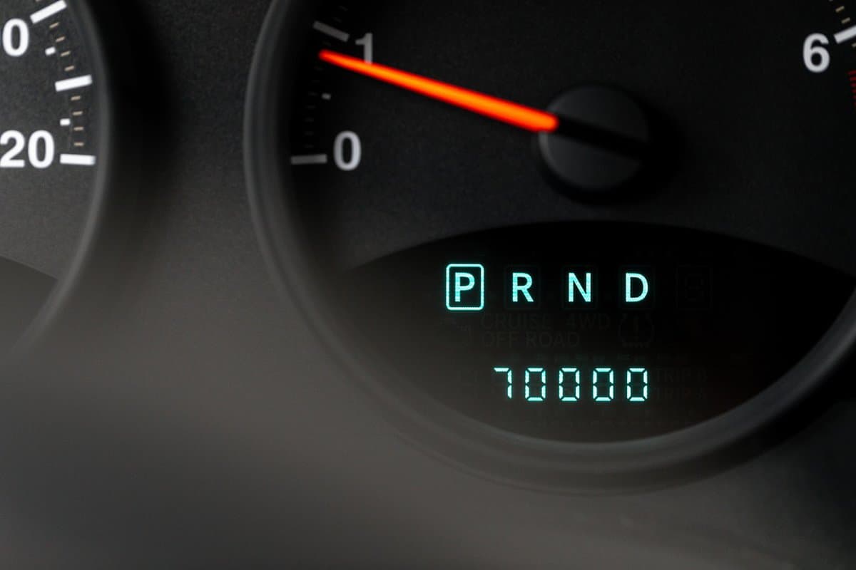 Light up digital modern odometer in a car with a black interior tellimg you the mileage and rpm