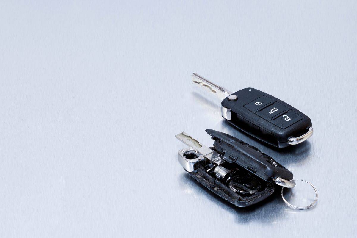 Locksmith broken or damaged car key fob and new remote vehicle key on aluminum background