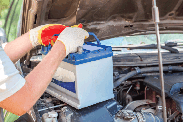 Maintenance of the machine. A male car mechanic takes out a battery from under the hood. How To Vent A Battery In The Trunk [Step By Step Guide]