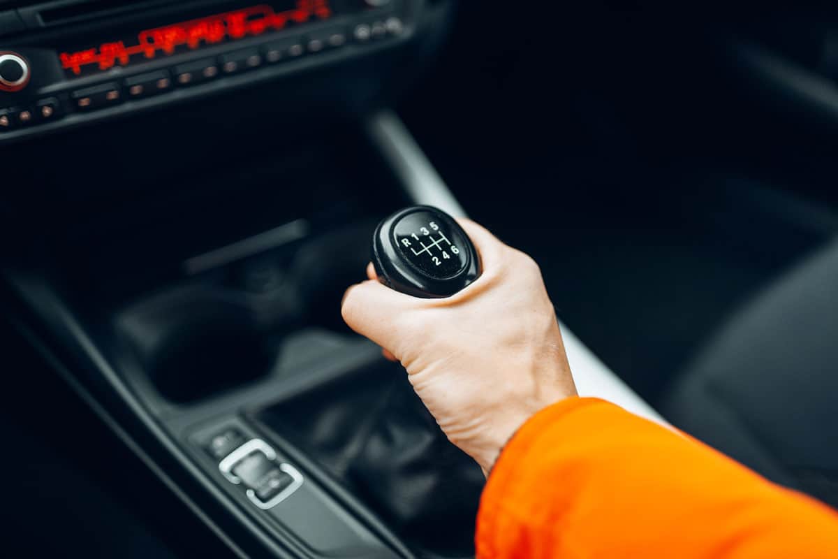 Man's hand switches manual transmission