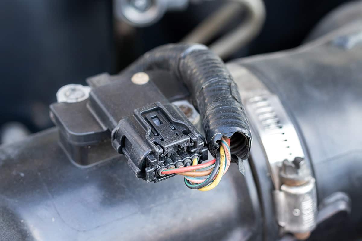 Mass air flow (MAF) sensor under the open hood of a car