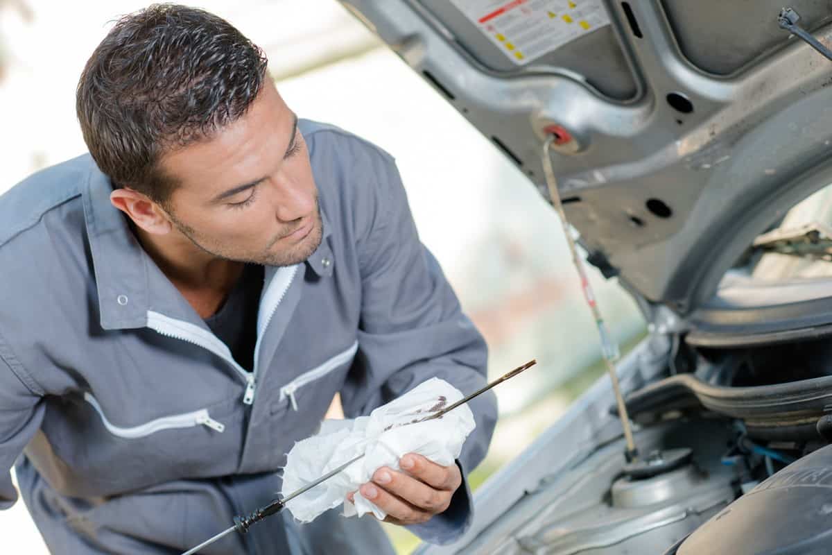 Mechanic checking the oil level of a car