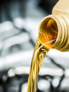 Pouring motor oil to car engine. Fresh yellow liquid change with back light. Maintenance or service vehicle concept. - What Is The Best Oil For VW Beetle?