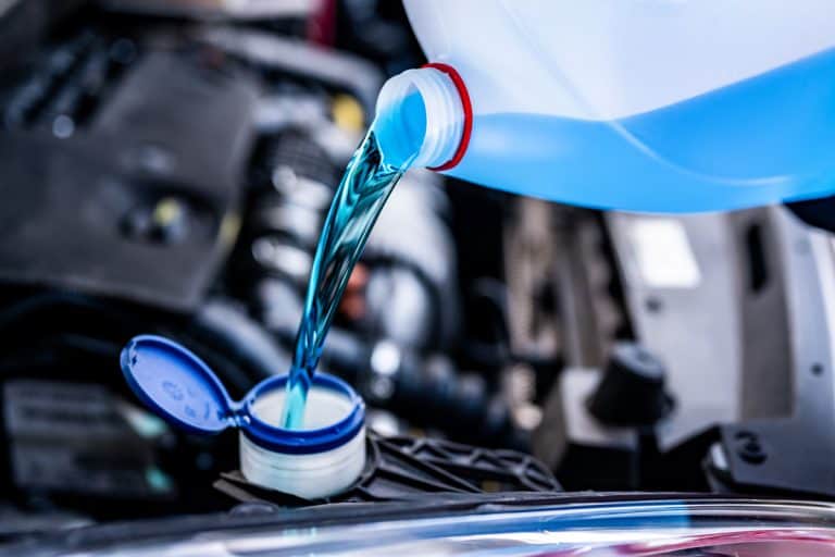 Pouring antifreeze. Filling a windshield washer tank with an antifreeze in winter cold weather. , Does Antifreeze Damage Car Paint? [And How To Fix It]