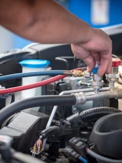 Servicing car air conditioner. Service station. Car repair. auto mechanic Check the pressure and leak. for use on air condition systems, Freon Leak In Car - Is It Dangerous? What To Do?