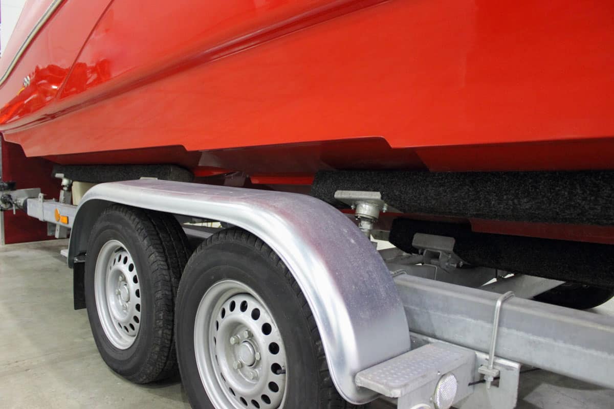 Two-axle boat trailer close-up with a red powerboat, motorboat transportation