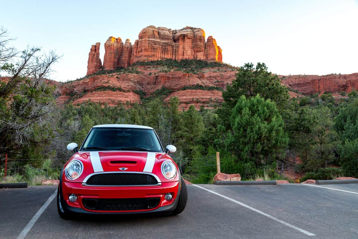 hot red metallic paint of mini cooper and white stripes on road