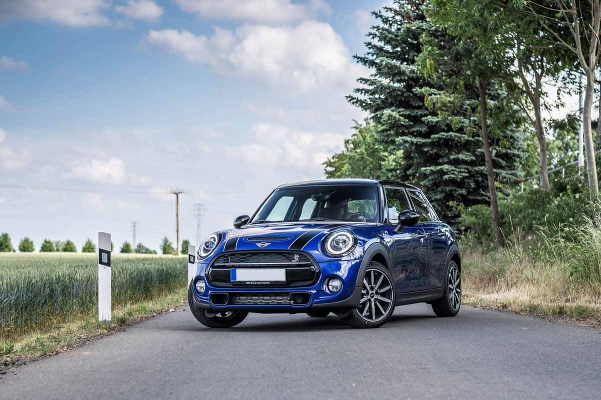 metallic blue paint mini cooper on the middle of the road