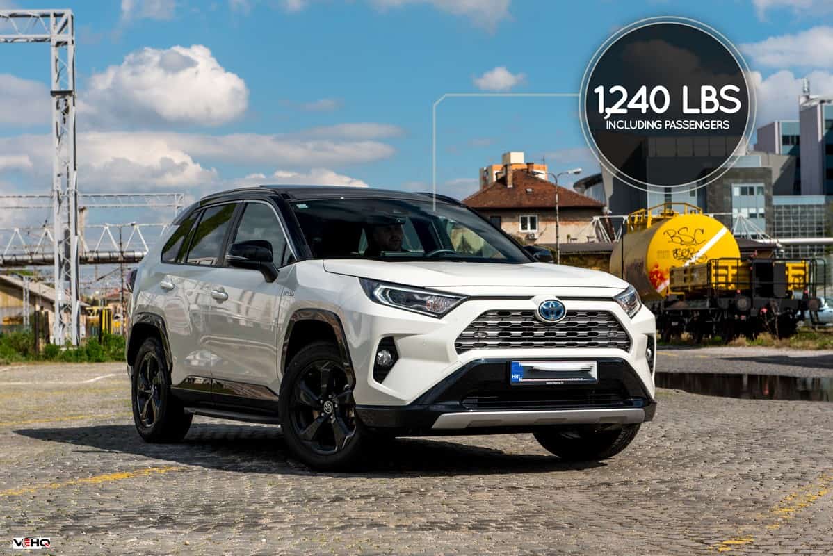 New Toyota RAV 4 Hybrid. Modern SUV transport vehicle in urban environment with blue sky in background. White Toyota car with new Hybrid technology., How Much Weight Can A Toyota Rav4 Carry?