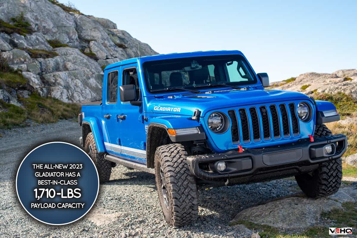 A vibrant blue Jeep Gladiator Rubicon truck 4x4 off road and parked on the side of a hill with the blue ocean, blue sky, and clouds in the background., How Much Weight Can A Jeep Gladiator Carry?