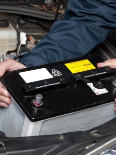 A car mechanic replaces a battery during maintenance. - Can A Car Battery Have Good Voltage And Still Be Bad?
