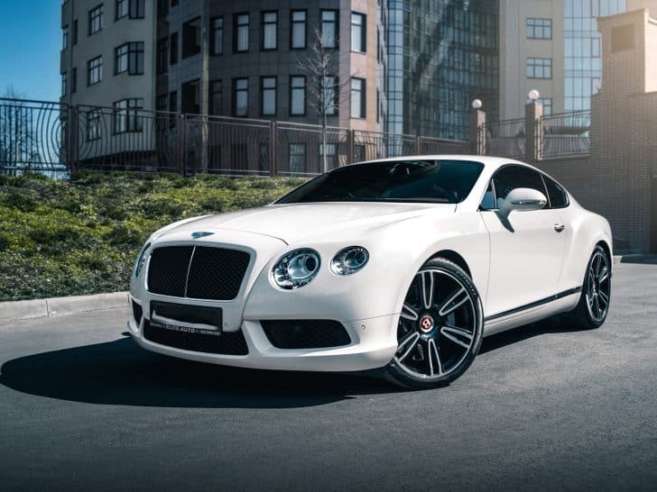 white Bentley Continental GT with building beside it, Why Is My Bentley Continental AC Not Working [3 Possibilities & Fixes]