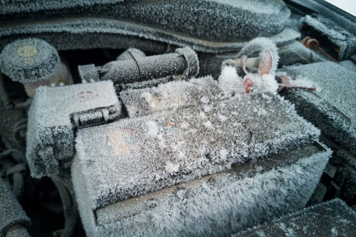 Car battery covered in snow and ice