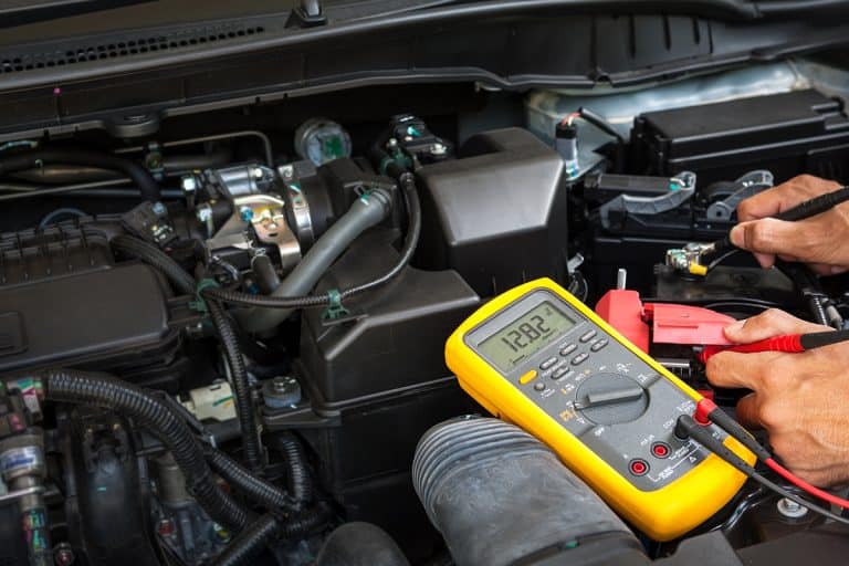 A car mechanic is using a multimeter with voltage range measurement to check the voltage level of the car battery, Remote Start Is Draining My Battery - Why? What To Do?