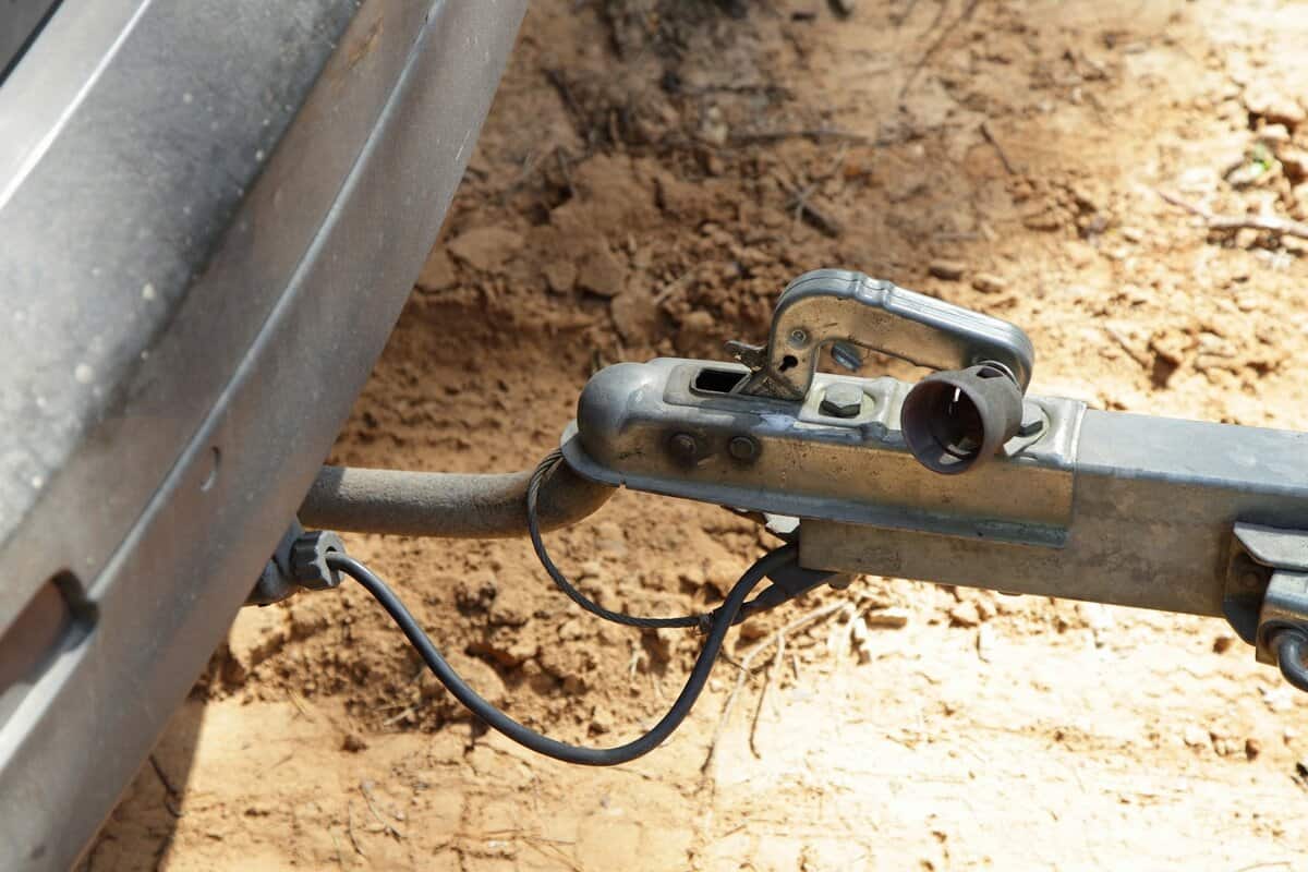Car tow hitch with trailer lock handle and electrical socket close up side view, safety driving with a trailer connection 