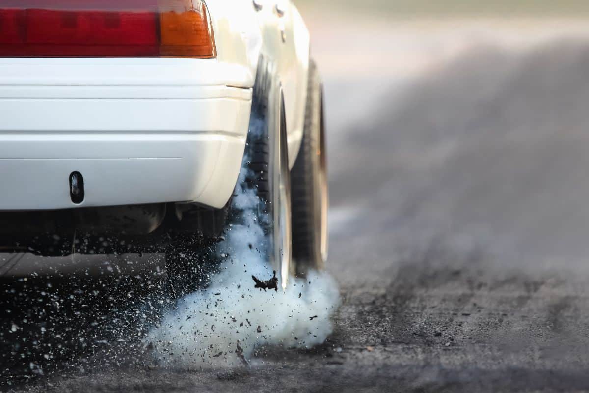 Drag racing car burns rubber off its tires in preparation for the race. 
