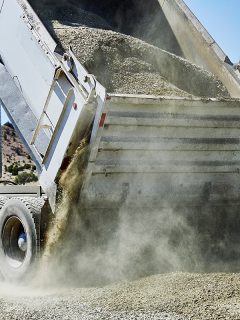 Dump truck spreading gravel on a dirt driveway, How To Tailgate Spread With A Dump Truck
