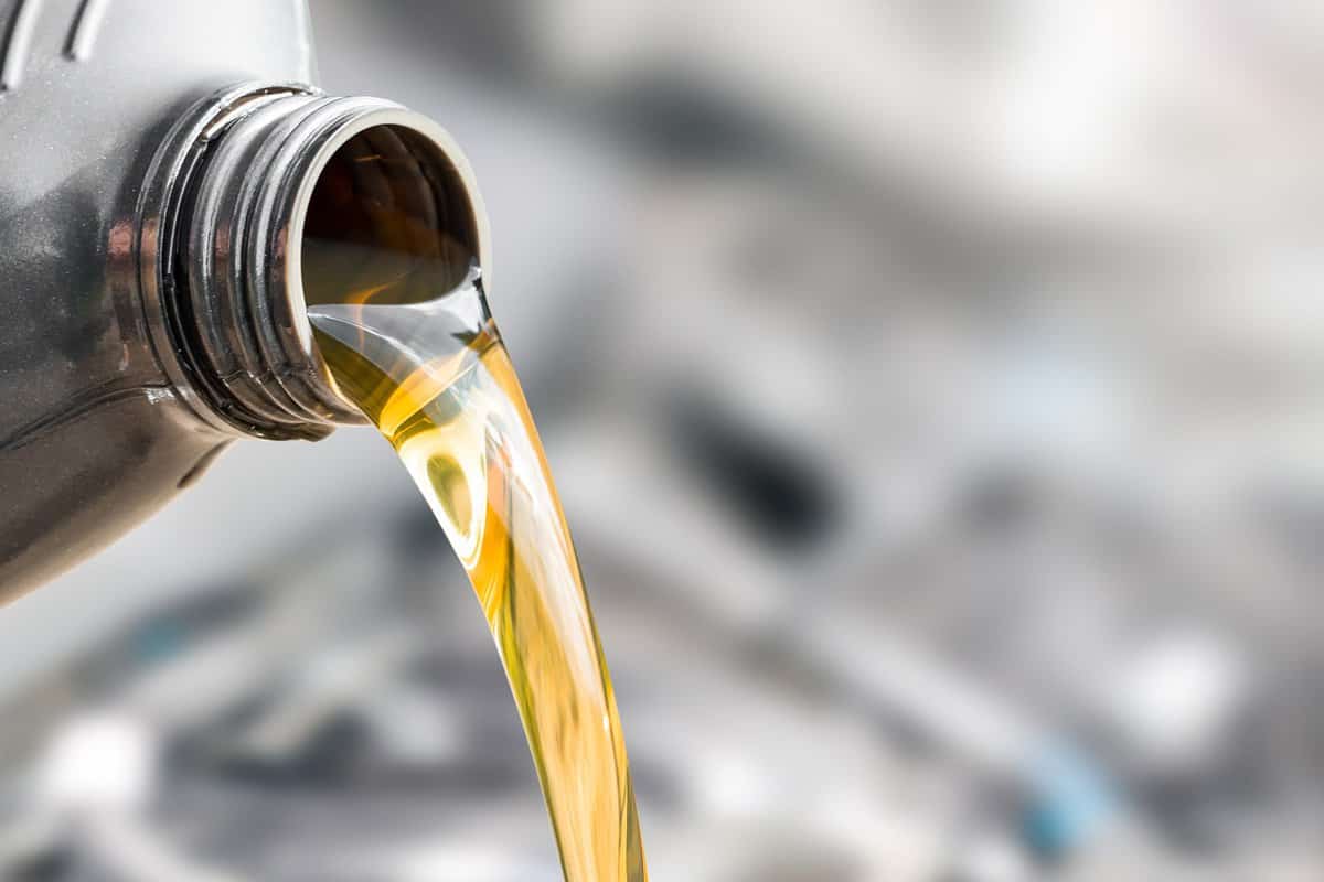 Pouring oil to car engine. Fresh oil poured during an oil change to a car. 