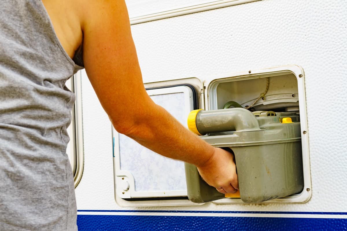 Woman placing back a grey water tank