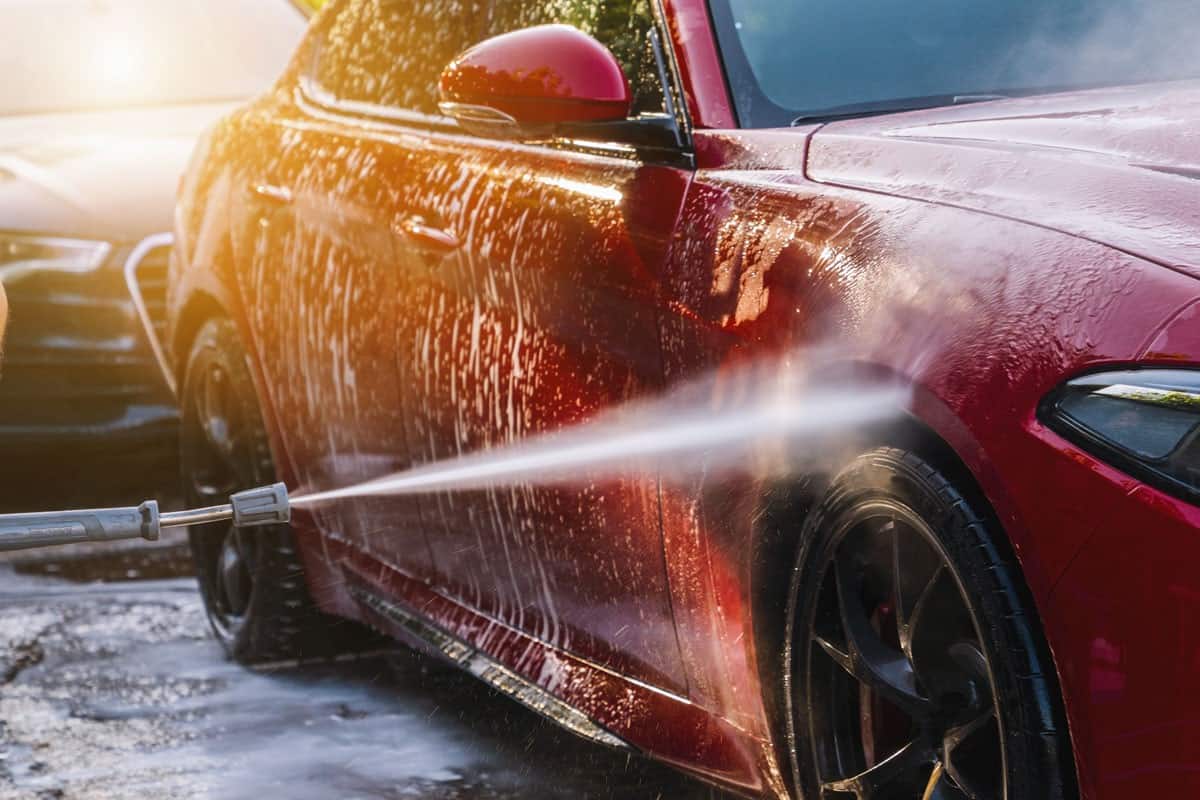 cleaning red car using high pressure