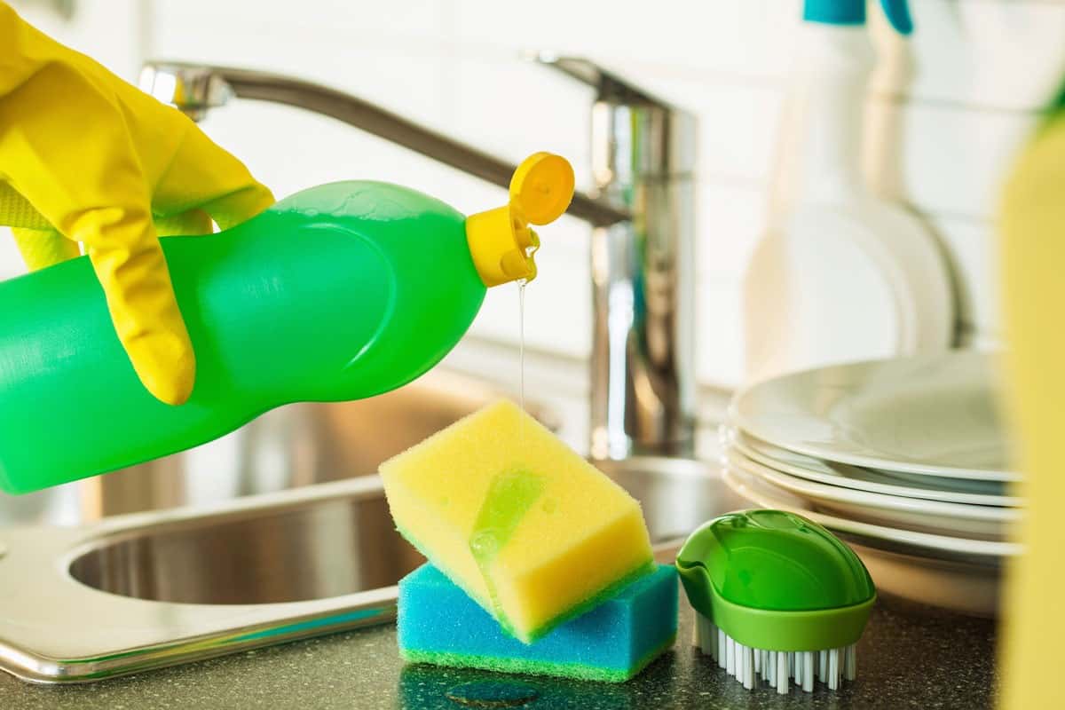 pouring dishwashing liquid on sponge kitchen