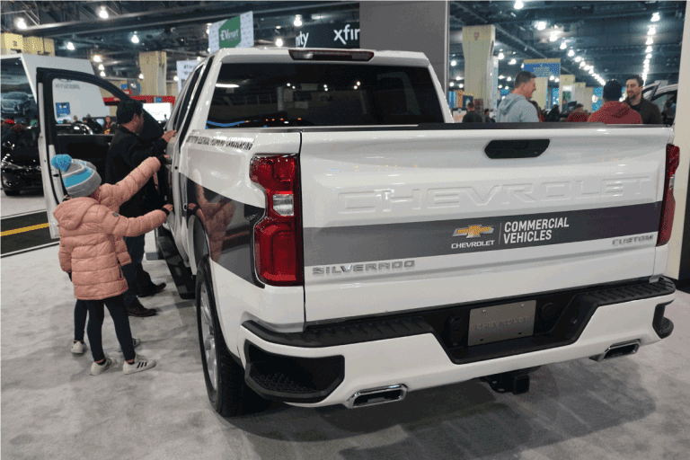 rear view of the brand new Chevy Silverado, kids in sweaters on the side of the vehicle. What Can A Silverado HD Truck Tow. How To Tell If Your Silverado Is HD