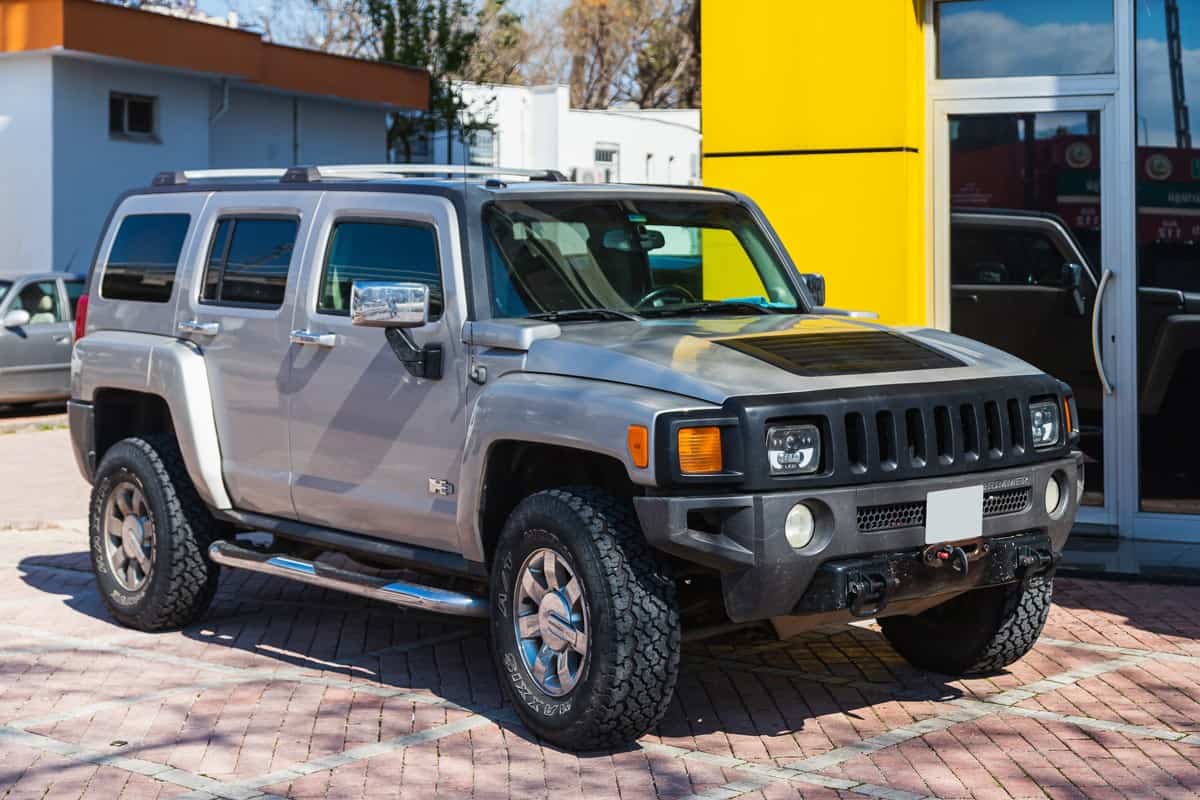 silver Hummer H3 is parked on the street on a warm summer day