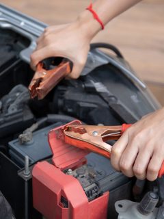 Asian young woman charging a car battery from the other car by using battery connector jump between battery, Asian young woman charging a car battery from the other car by using battery conne, Can I Start A Car With A Battery Charger Connected?ctor jump between battery