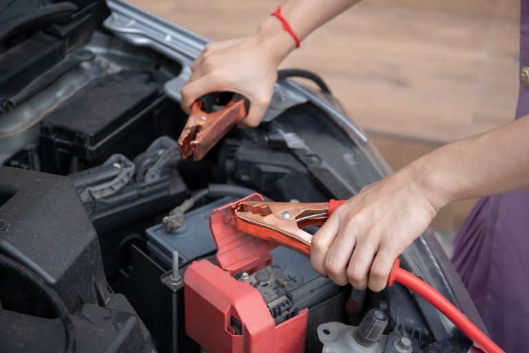 Asian young woman charging a car battery from the other car by using battery connector jump between battery, Asian young woman charging a car battery from the other car by using battery conne, Can I Start A Car With A Battery Charger Connected?ctor jump between battery