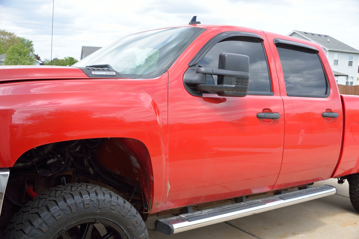 Bright Red 2008 Chevrolet Silverado 2500 HD with view of the doors on drivers side and part of the hood.