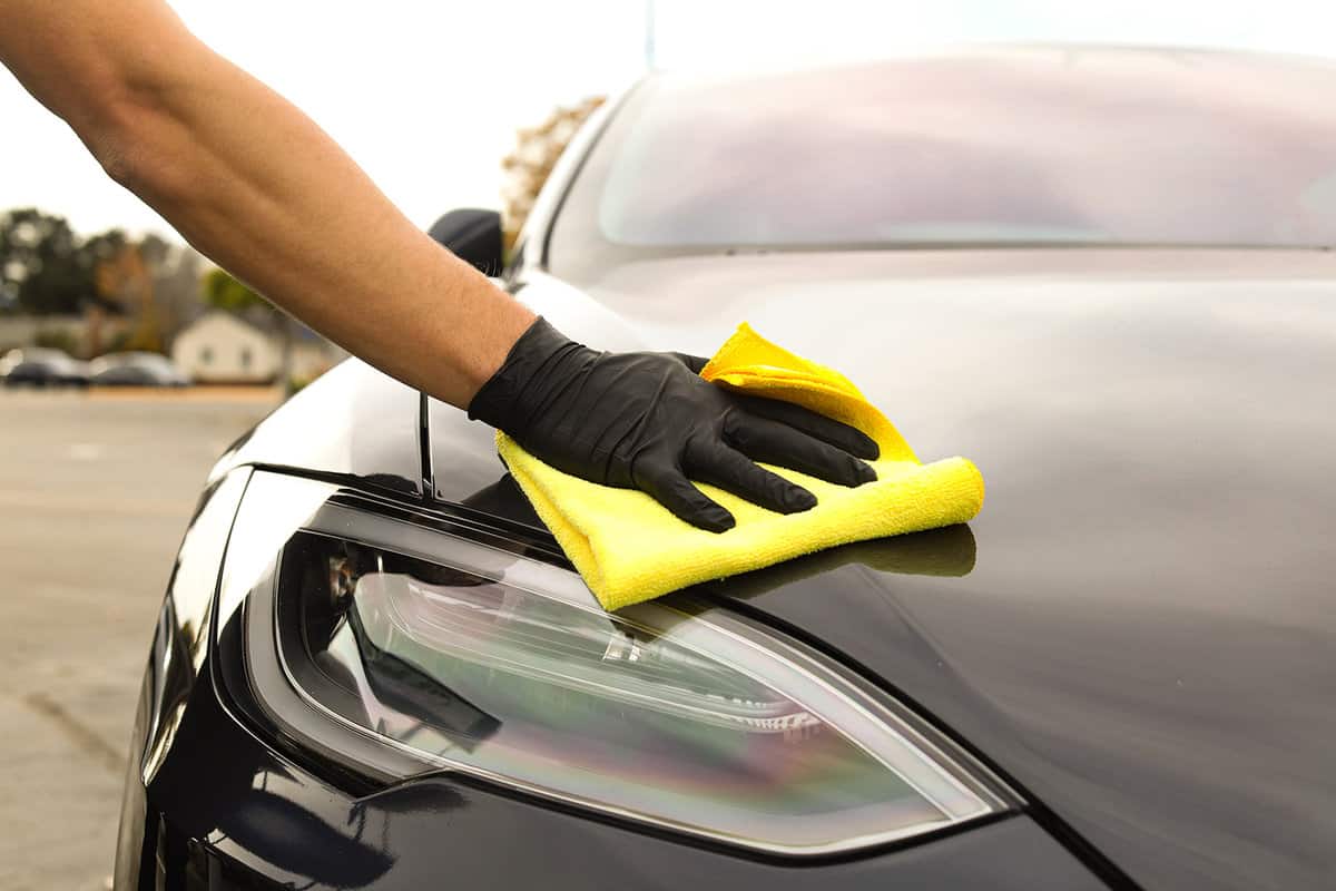 Car cleaning Tesla using yellow microfiber cloth