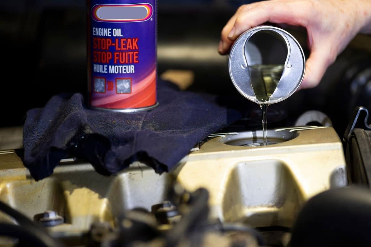 Engine oil leak plug for gasoline and diesel engines, a hand pouring the additive inside the engine