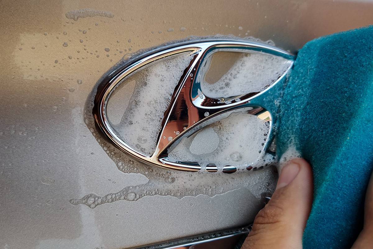 Male hand cleaning up hyundai logo with soap