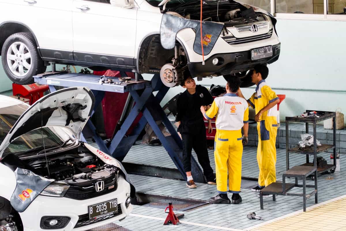 Mechanics work to repair cars in workshops.