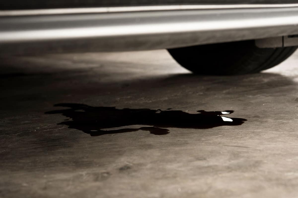 Oil leak or drop from engine of car on concrete floor , check and maintenance auto service 